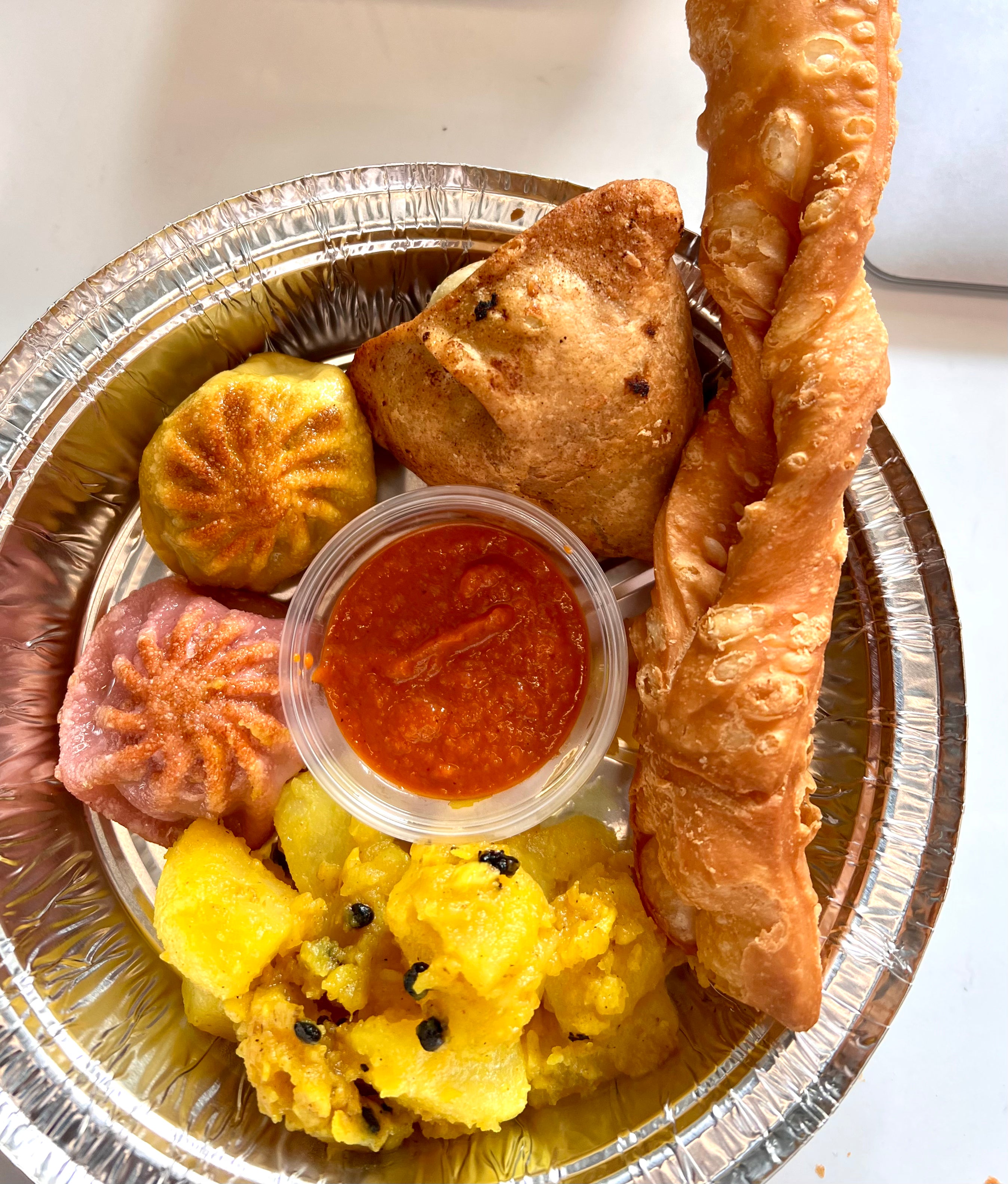 Platter (Try them all) - 2 Momo, 1 Samosa, 1 Khapse, Aludam (Potato Salad) Momo Sauce and Mango Lassi (Smoothie Like beverage) (SB)